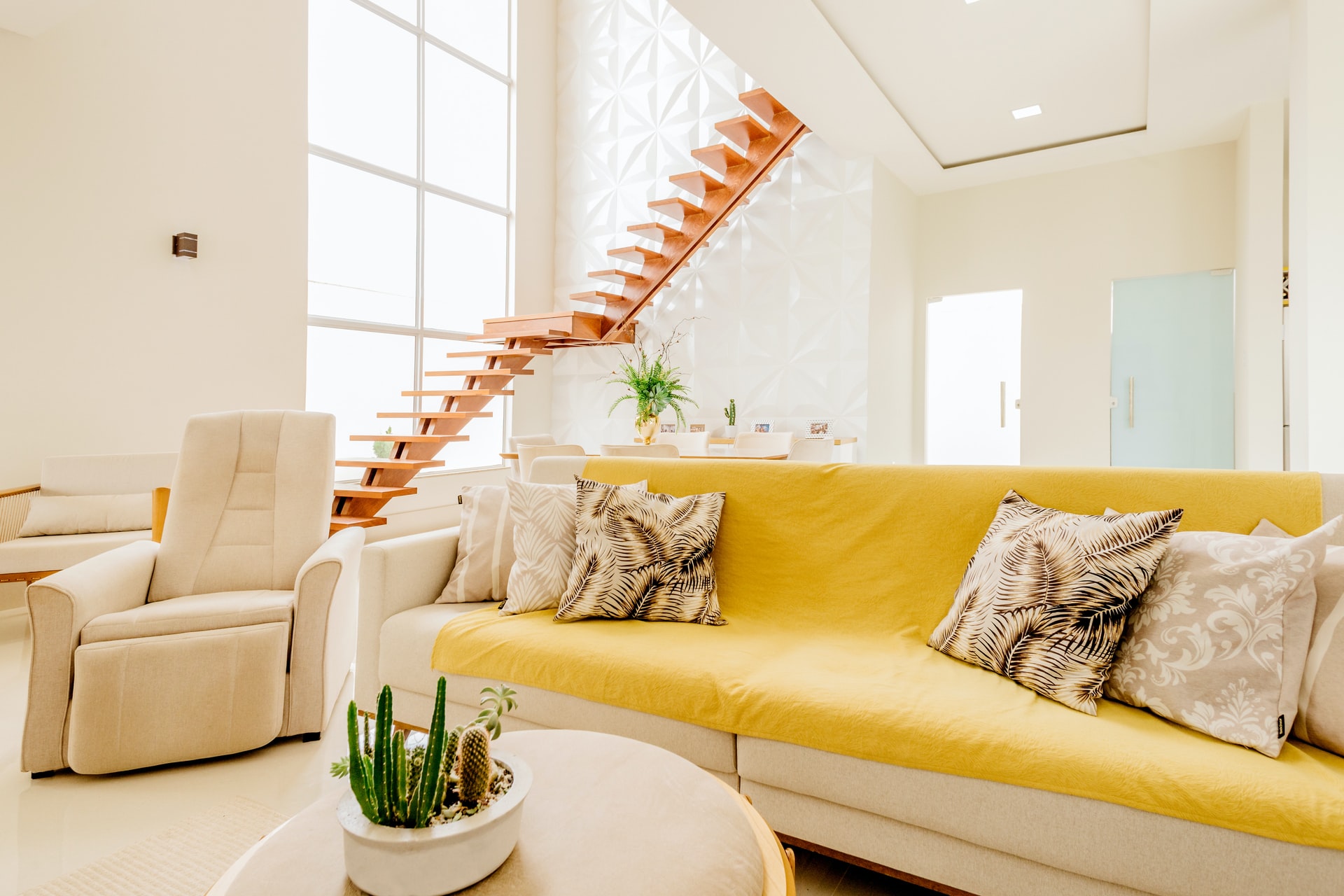 A sofa with a yellow blanket, an armchair, and a coffee table.