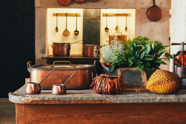 A kitchen countertop with copper pots and pans