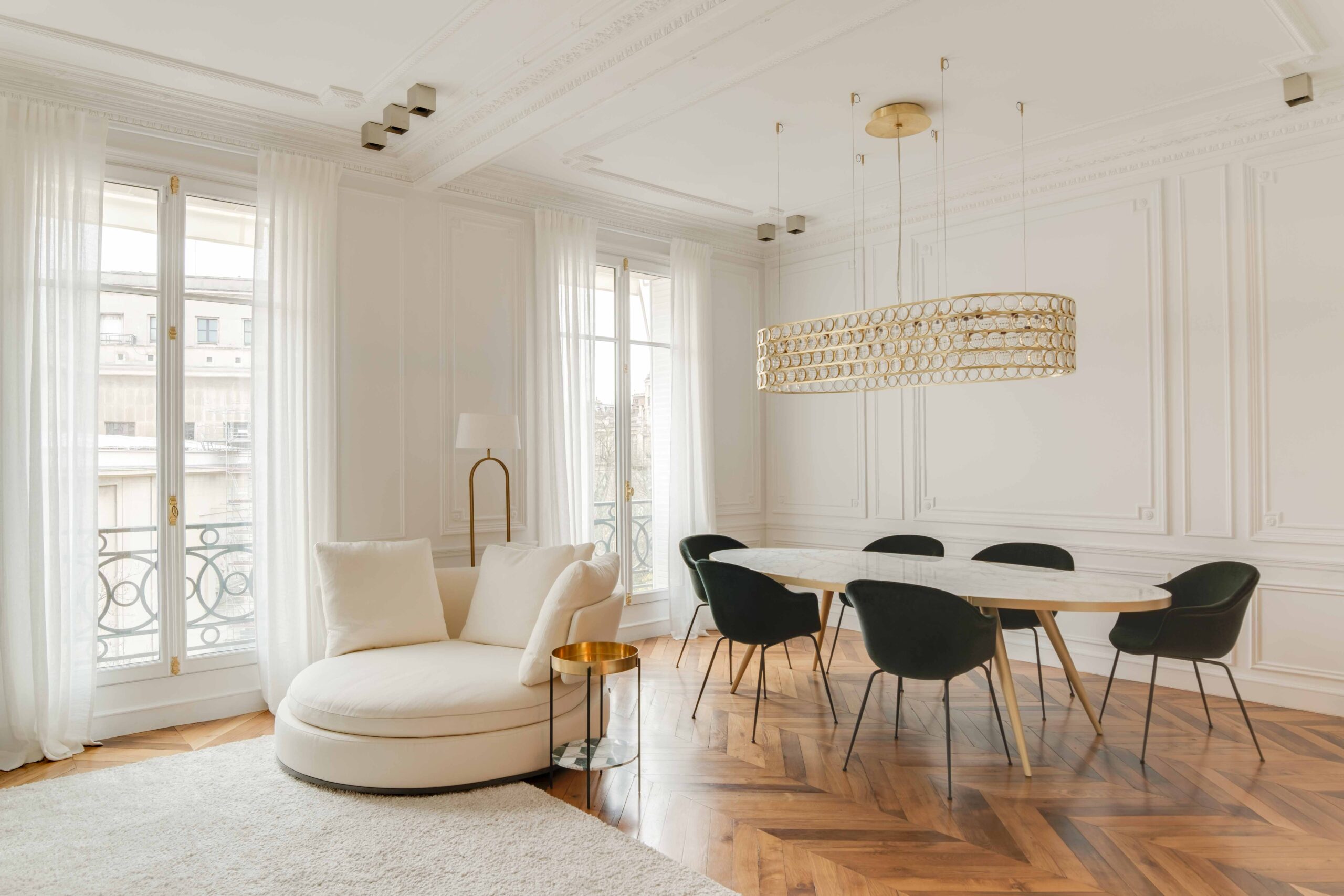 An oval dining room table with curved chairs and a round armchair