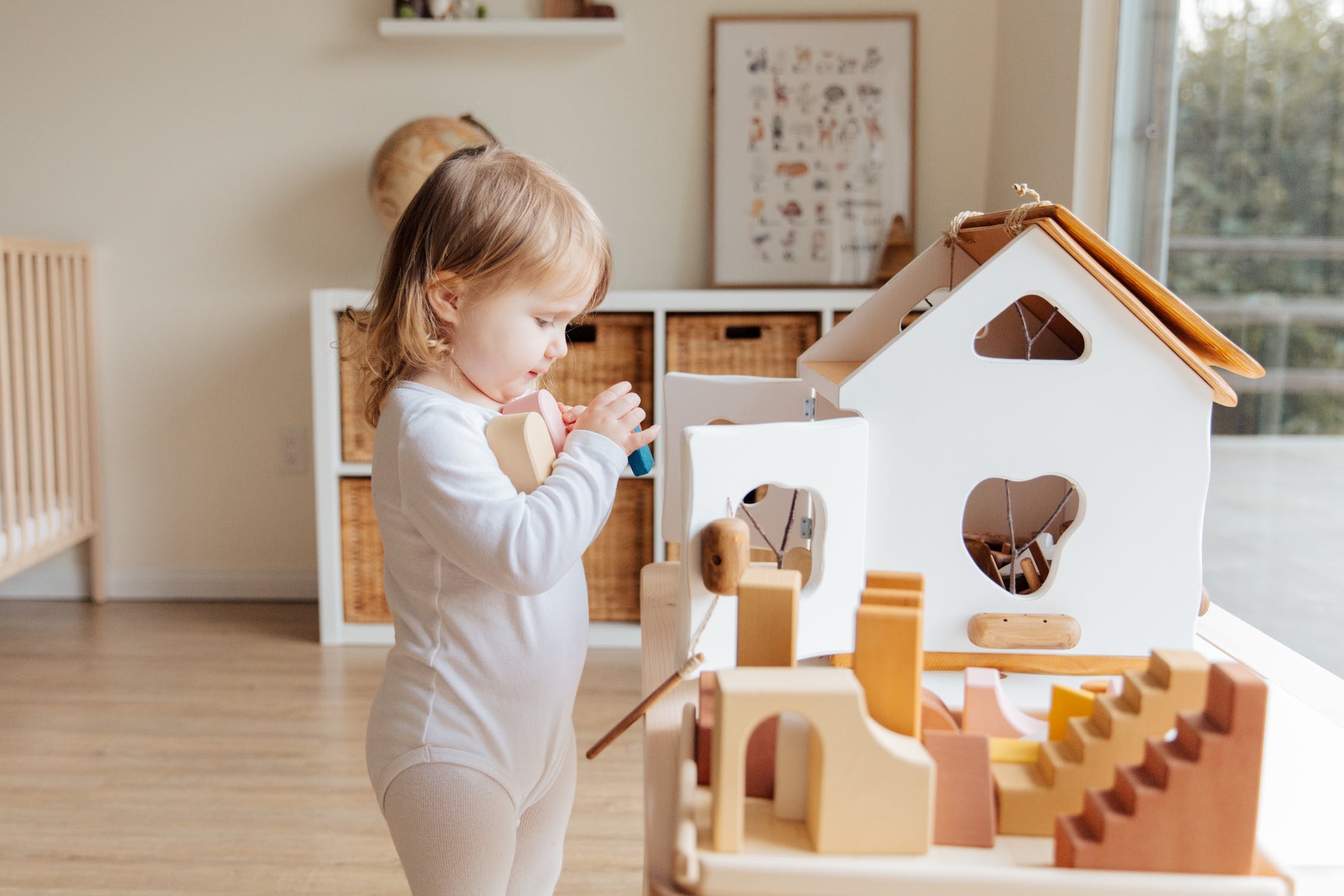 A girl playing with wooden toys in her room