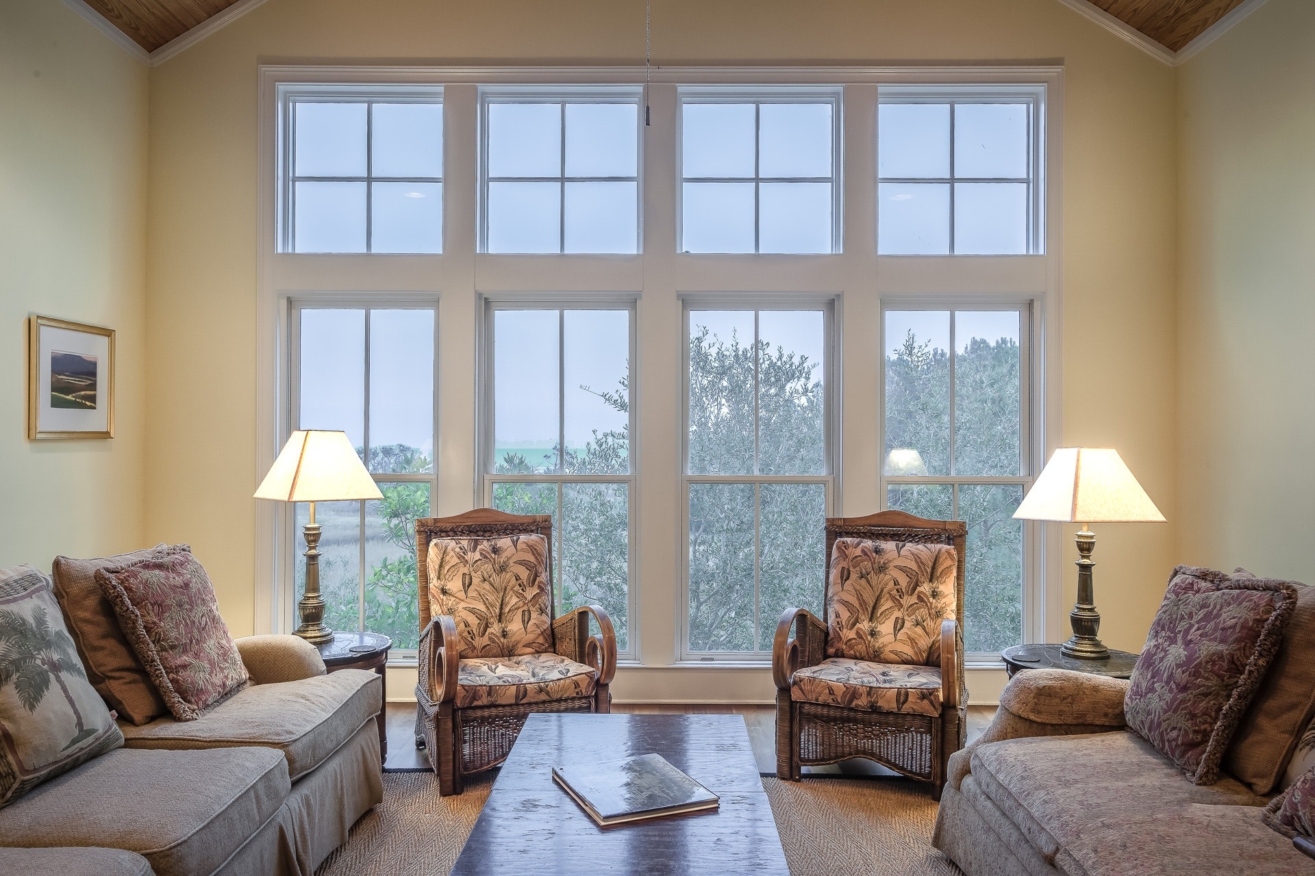 Room with many windows and brown chairs.