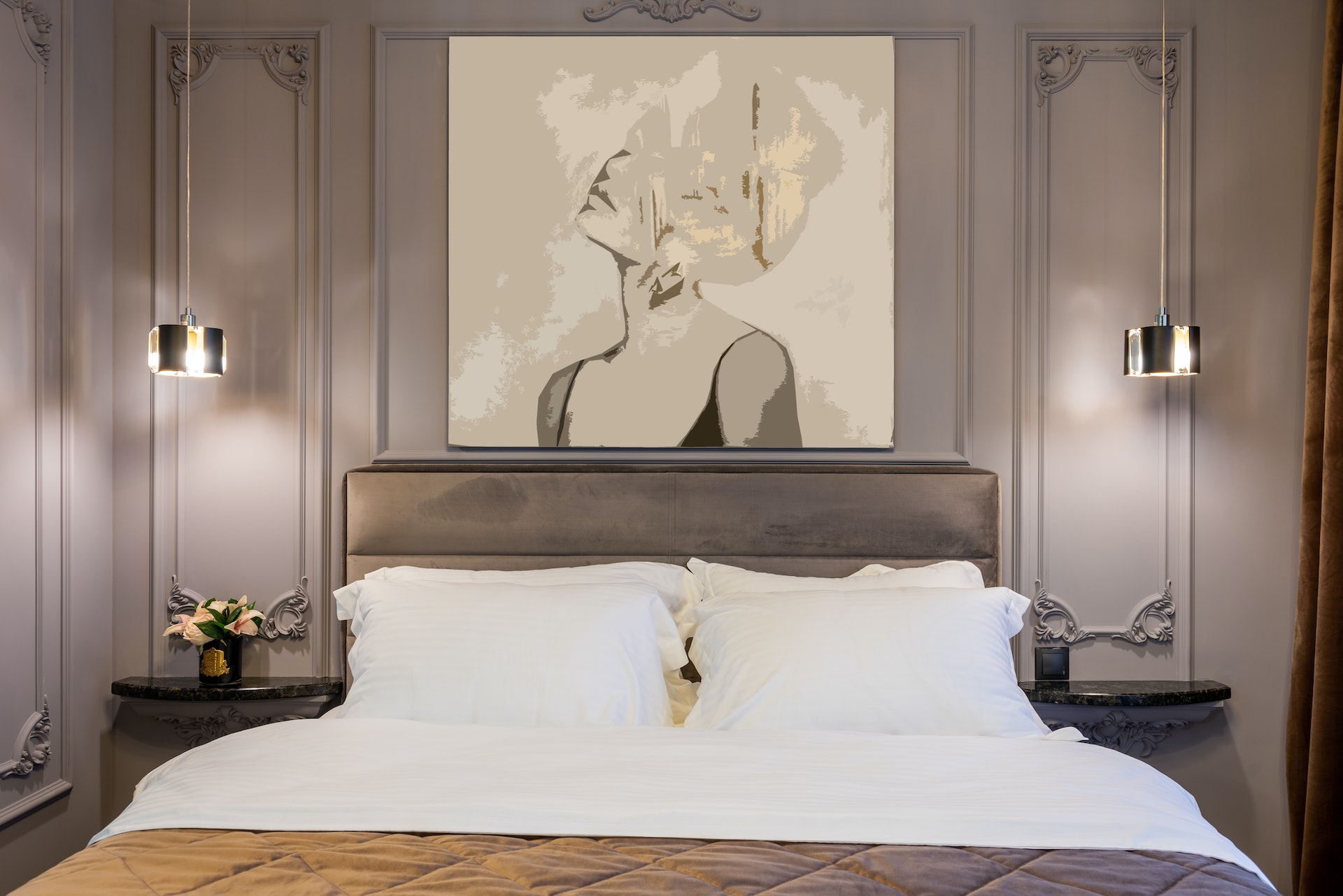 A grey and white artwork above a bed